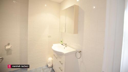 伯马吉Beach Pad Unit1, 2 Wallaga Street, Bermagui的一间白色浴室，配有洗手池和镜子。