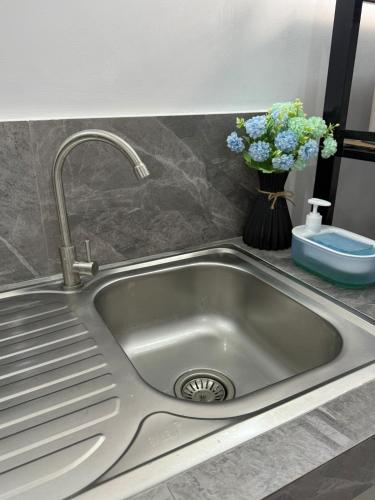 un lavandino con rubinetto e vaso di fiori di WedStays 1 