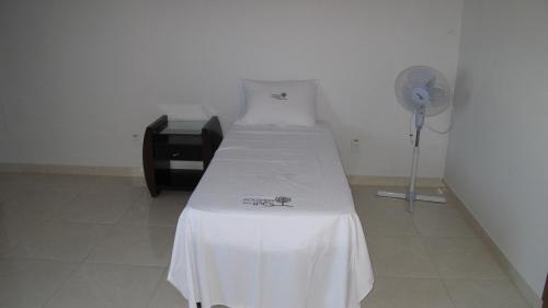 a hospital room with a bed and a fan at Pousada Flor Dos Ipês in Trindade