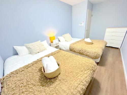 due letti in una stanza con pareti blu di OKINAWA POOLWILLA ONNA 4A - Vacation STAY 06955v a Baba