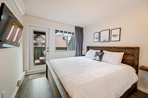 a bedroom with a large bed and a window at Private Hot Tub | Pool | AC | Free Parking in Whistler