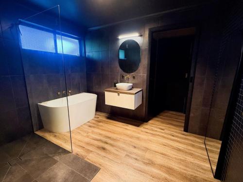 Black Diamond - Pet Friendly, Magnesium Spa في برايت: حمام مزود بحوض استحمام ومغسلة ومرآة