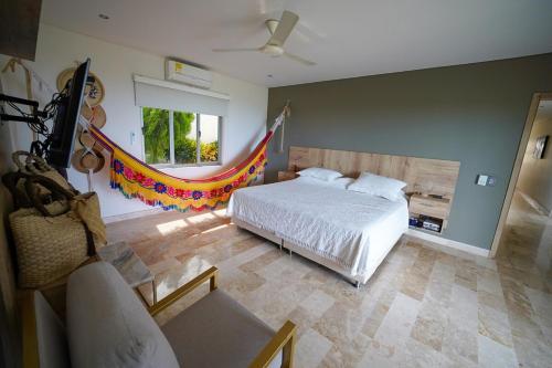 Casa Juliana vista al mar piscina y jacuzzi في Tubará: غرفة نوم بها سرير وكرسي ونافذة