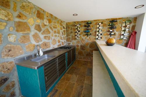 Casa Juliana vista al mar piscina y jacuzzi في Tubará: مطبخ مع حوض وجدار حجري