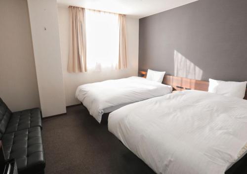 a hotel room with two beds and a window at ホテルグリーンヒル美浜 in Mihana
