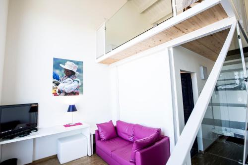 a living room with a purple couch and a staircase at Il Portico in Fano
