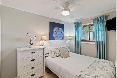 a bedroom with a white bed and a ceiling fan at SC206A: 206A Sea Cabin in Isle of Palms