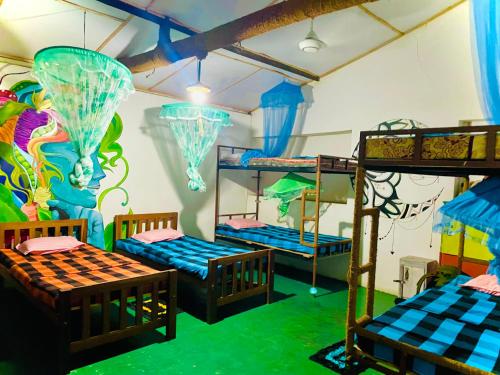 a room with three bunk beds and a mural at Dub & Drum hostel in Sigiriya