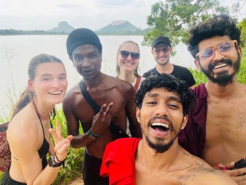a group of people posing for a picture by the water at Dub & Drum hostel in Sigiriya