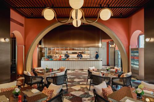 un restaurant avec des tables et des chaises et une cuisine dans l'établissement Hotel Indigo Wuxi Qingming Bridge, à Wuxi