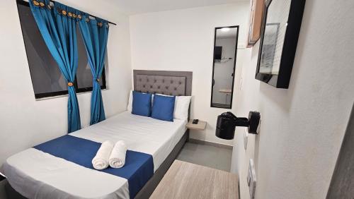 麦德林Hospedaje Andaliving Campo Valdes的小房间设有一张带蓝色枕头的床