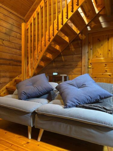 a couch with two pillows sitting under a staircase at ISE Family Cabin in Ise