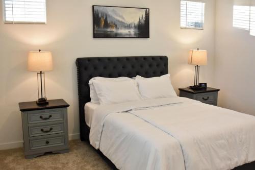 a bedroom with a bed and two night stands with lamps at BnB Vacation Home in Queen Creek