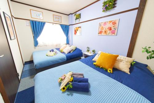 two beds in a small room with blue sheets at Belmont 101 3min to Station Easy Access Ueno Asakusa Skytree Sleeps 5 in Tokyo