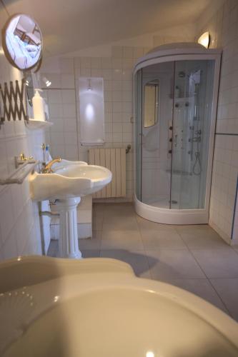 une salle de bain blanche avec un lavabo et une douche dans l'établissement Maison De L'Orb, à Béziers