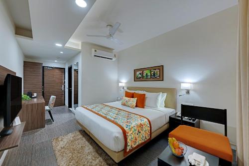 古尔冈Ahuja Residency GCR的一间配有床和电视的酒店房间