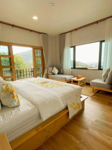 a bedroom with a large bed and large windows at Seacrest Boutique Kohtao Thailand in Ko Tao