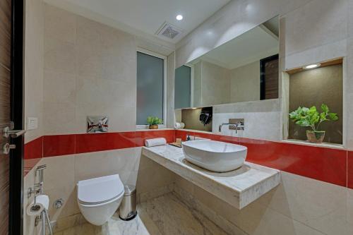 古尔冈Ahuja Residency GCR的浴室里有洗手池、马桶和镜子。