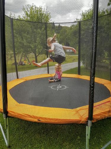 a young girl is jumping on a trampoline at Biobauernhof Stegerbauer in Maria Alm am Steinernen Meer