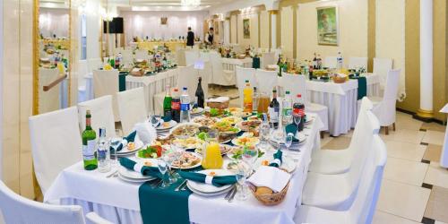 a dining room with white tables and white chairs at Hotel Mars in Lviv