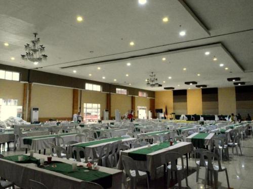 um grande salão de banquetes com mesas e cadeiras verdes em Big Daddy Hotel and Convention Center em Agusan Pequeño