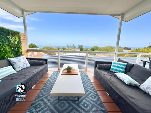 a patio with couches and a table on a deck at Modern Coastal with Sparkling Sea Views in Victor Harbor in Victor Harbor