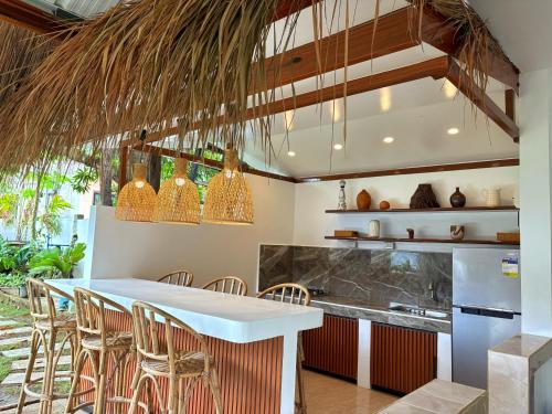 a kitchen with a bar with chairs and a table at Villa Aniani in El Nido