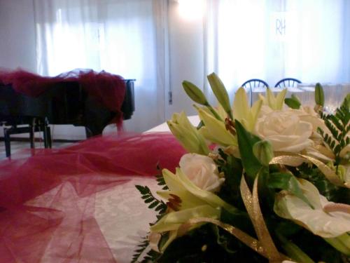 a vase of flowers on a table in a room at Rometta Hotel in Cittadella