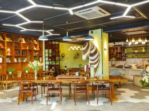 uma sala de jantar com mesas e cadeiras de madeira em Immersing Hotel Guilin Two Rivers and Four Lakes Dongxi Alley em Guilin