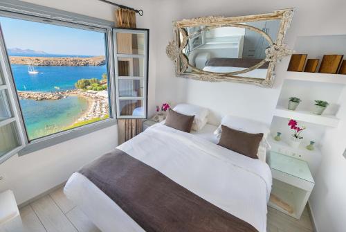 a bedroom with a bed and a large window at Lindos Shore Boutique Villa with sea view in Lindos