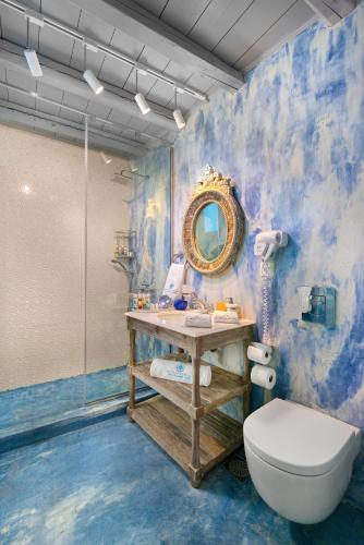 a bathroom with a toilet and a sink and a mirror at Lindos Shore Boutique Villa with sea view in Lindos