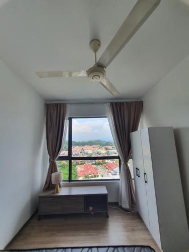 a room with a ceiling fan and a large window at JT Homestay in Kota Kinabalu