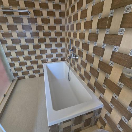 bagno con lavandino bianco e parete in legno di Natures Harmony Resort a Polem