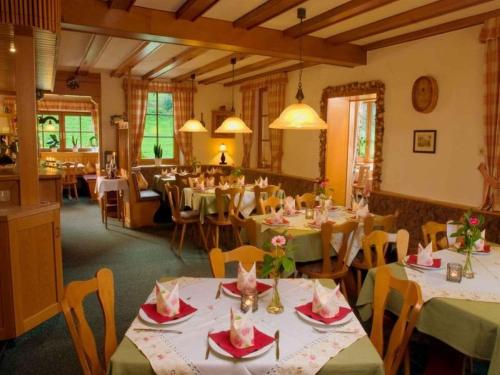 a restaurant with tables and chairs in a room at Gasthaus Hohberg in Durbach