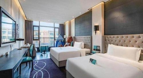 une chambre d'hôtel avec deux lits et un bureau dans l'établissement Xana Hotelle Luzhou High-Speed Railway Station Trading Market Passenger Terminal, à Luzhou