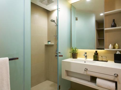 a bathroom with a sink and a shower and a mirror at Oasia Residence Singapore by Far East Hospitality in Singapore