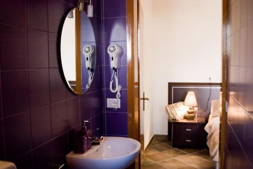 ビビオーネにあるCasa Augustaのバスルーム(シンク、鏡、ベッド付)
