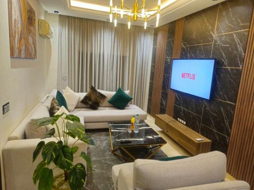 ein Wohnzimmer mit Sofa und Fernseher in der Unterkunft modern apartment opposite to HASSAN2 MOSQUE with side SEA view with sports machines with free underground GARAGE prohibited for unmarried couples of Arab origin space of 85m apartment too QUIET in Casablanca