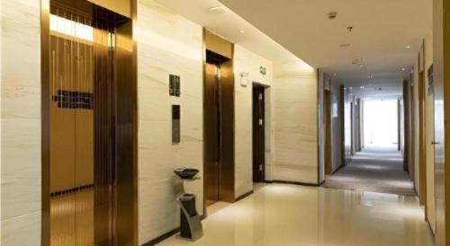 a hallway of a building with wooden doors and floors at City Comfort Inn Tonglu Fuchun River Qiaolin Road in Tonglu