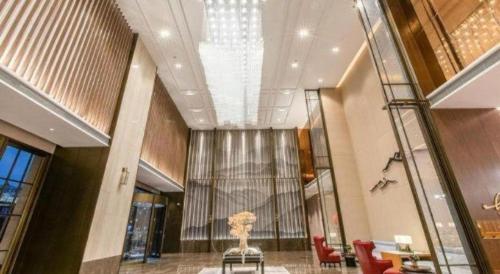 a lobby with a vase with a tree in it at Echeng Hotel Nanning Huqiu Metro Station in Nanning