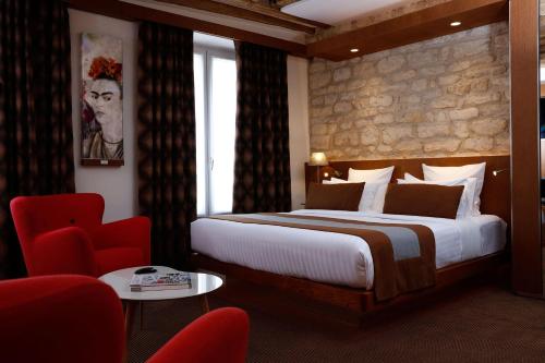a bedroom with a large bed and a red chair at Select Hotel in Paris