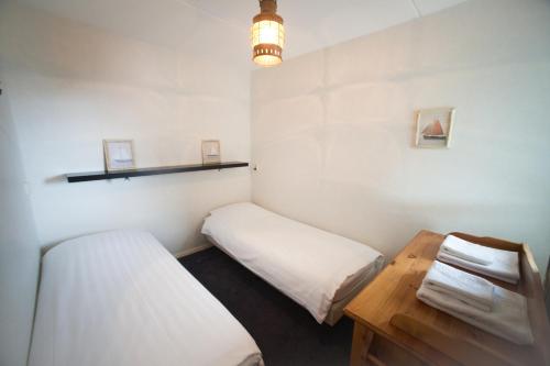 a small room with two beds and a table at Hanzehuis Appartementen in Stavoren