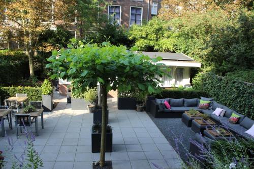 a garden with a couch and a tree in the middle at Prinsengracht Hotel in Amsterdam
