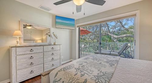a bedroom with a bed and a dresser and a window at Hemingway House - 117 in Siesta Key
