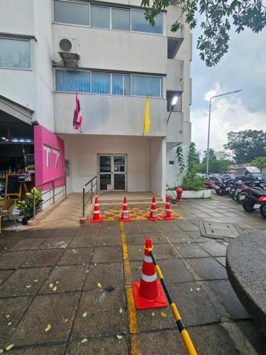 a parking lot with orange cones in front of a building at CinCin Popular Condo in Thung Si Kan