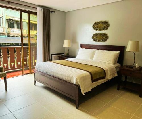 Un dormitorio con una cama grande y un balcón. en Crosswinds Standard Suite, en Ulot