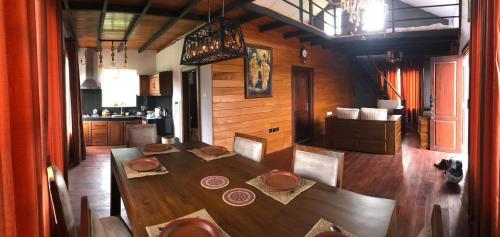 ein hölzernes Esszimmer mit einem Tisch und einer Küche in der Unterkunft Tidenest Cottage in Nuwara Eliya