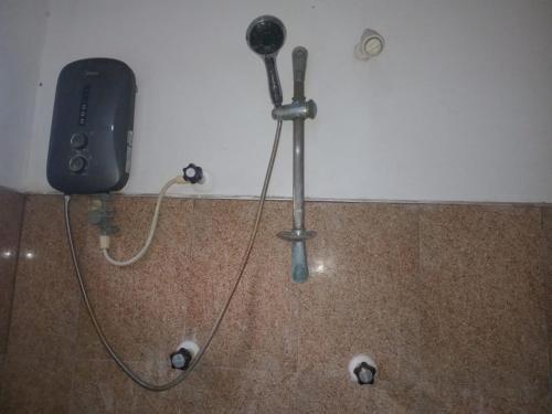 Un secador de pelo está fijado a una pared. en BG Guest House Jaffna, en Tirunelveli East