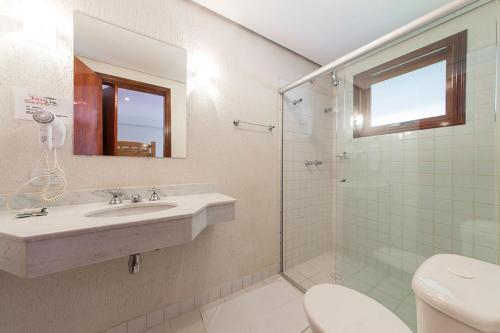 a bathroom with a sink and a shower and a toilet at Pousada Joia da Serra by Hotel Platanus in Campos do Jordão