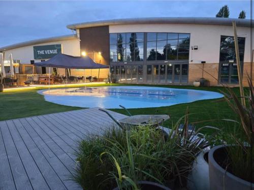 Un gran edificio con una piscina en frente. en Billing Aquadrome - Bird Lake View, en Great Billing